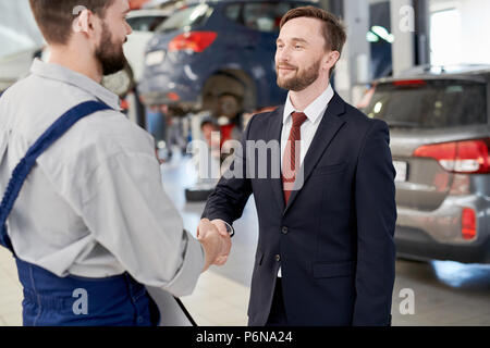 Imprenditore stringono le mani con meccanico Foto Stock