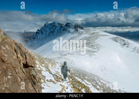 Una collina walker in tempesta di neve, sul crinale di Sgùrr un' Chaorachain nelle colline Applecross, regione delle Highlands, Scotland, Regno Unito. Foto Stock