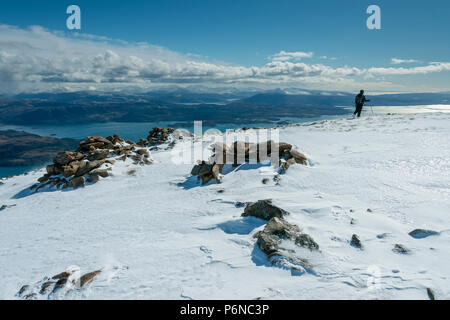 Una collina walker vicino alla cima della cresta di Sgùrr un' Chaorachain nelle colline Applecross, regione delle Highlands, Scotland, Regno Unito. Foto Stock