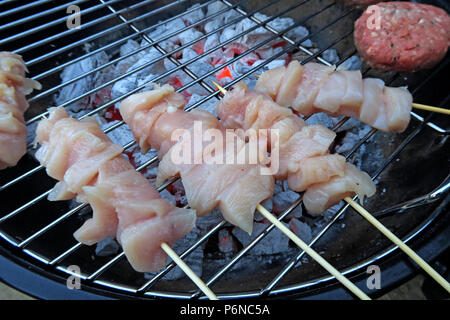 Pollo crudo, su un barbecue, pollo crudo, carne non cotta, su carbone su un giardino grill, barbecue estivo Foto Stock