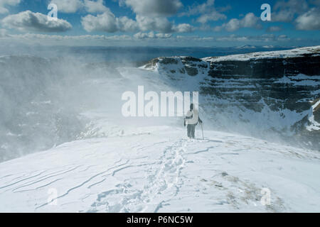 Una collina walker in tempesta di neve, sul crinale di Sgùrr un' Chaorachain nelle colline Applecross, regione delle Highlands, Scotland, Regno Unito. Foto Stock