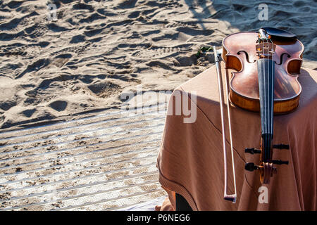 Antica violino recante sulla spiaggia in estate Foto Stock
