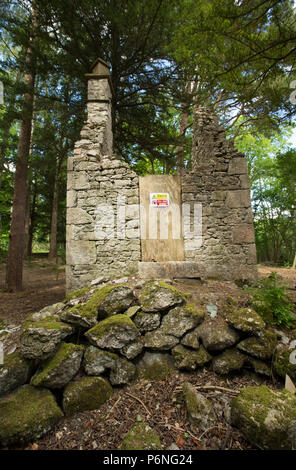 I resti di un cottage in pietra con terreno cancellata attorno ad esso nel bosco in prossimità di Hawes lago d acqua in Silverdale con cartelli di avvertimento di non entrare. Hawes Wa Foto Stock