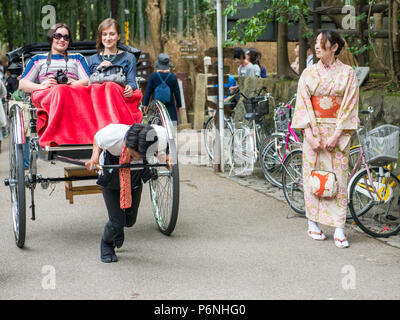 Tradizionali mano tirato rickshaw Sagano nella foresta di bambù di Arashiyama alla periferia di Kyoto, Giappone. Foto Stock