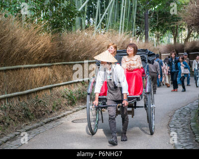 Tradizionali mano tirato rickshaw Sagano nella foresta di bambù di Arashiyama alla periferia di Kyoto, Giappone. Foto Stock