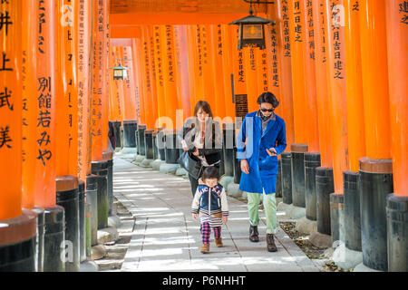 I turisti giapponesi esplorare Fushimi Inari Taisha a Kyoto, in Giappone. Lungo il percorso principale ci sono più di 10000 torii gates. Foto Stock