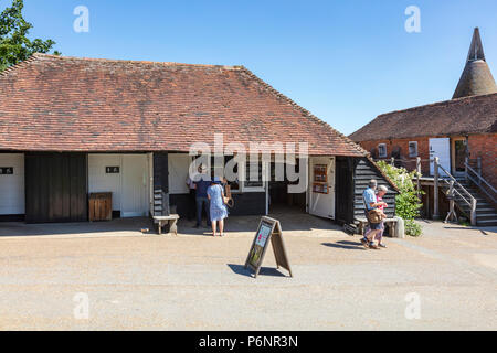 I visitatori che arrivano presso il castello di Sissinghurst Gardens su una intensa giornata d'estate. Preso da un pubblico Bridleway, Kent, Regno Unito Foto Stock