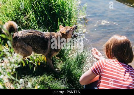 Foto di donna con cane vicino stagno Foto Stock