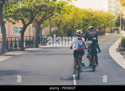 Famiglia sono a cavallo di biciclette a noleggio percorso. La fotografia con filtro vintage. Foto Stock