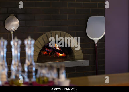 A legna tradizionale forno a legna con fiamma all'interno. Foto Stock