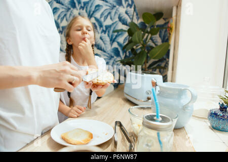 La felice sorridente famiglia caucasica in cucina prepara la colazione Foto Stock