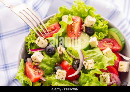 Fresca insalata greca è servita nella ciotola con forcella. Foto Stock