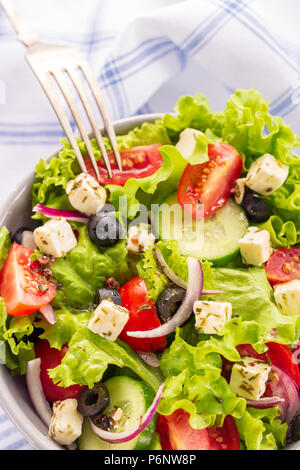 Fresca insalata greca è servita nella ciotola con forcella. Foto Stock