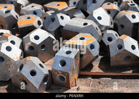 Moderno ponteggi industriali acciaio Parti di collegamento giaceva sul pavimento in legno Foto Stock