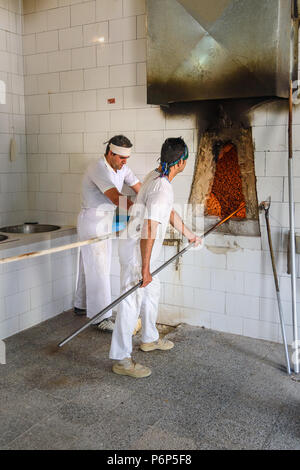 Khorramabad, Lorestan Provincia, Iran - 31 Marzo 2018: fornai al lavoro, preparare il pane tradizionale Sangak iraniana piccola pasticceria Foto Stock