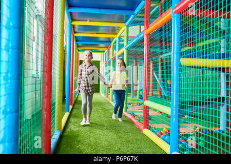 Bambine in esecuzione nel centro di riproduzione Foto Stock