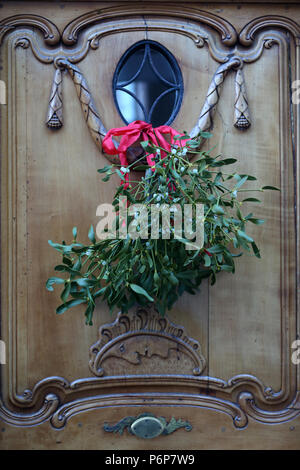 Decorazione di natale. Mazzo di vischio (Viscum album) appeso sulla porta di legno. Basilea. La Svizzera. Foto Stock