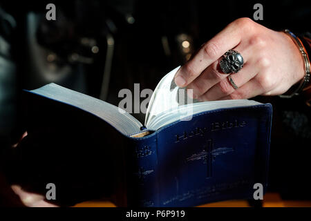 Uomo con anello di cranio la lettura della Sacra Bibbia. La Francia. Foto Stock
