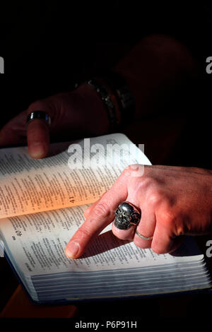 Uomo con anello di cranio la lettura della Sacra Bibbia. La Francia. Foto Stock