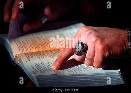 Uomo con anello di cranio la lettura della Sacra Bibbia. La Francia. Foto Stock
