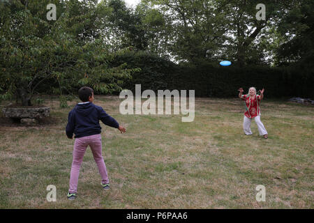 11-anno-vecchio ragazzo giocando frisbee con sua nonna. La Francia. Foto Stock