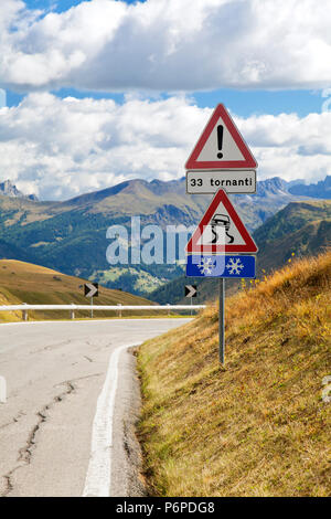 Avvertenza cartello stradale su una strada di montagna nelle Dolomiti, Italia Foto Stock