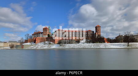 Bella vista sul castello di Wawel a Cracovia, Polonia, dal fronte fiume Vistola banca in inverno, le nuvole nel cielo blu in movimento, una lunga esposizione. Foto Stock