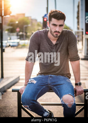 Attraente giovane uomo ritratto in una strada di città Foto Stock