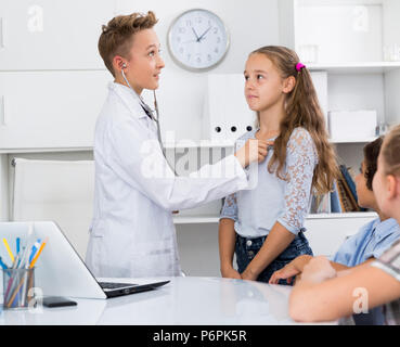 Giovane maschio medico in uniforme medica leader appuntamento con i bambini Foto Stock