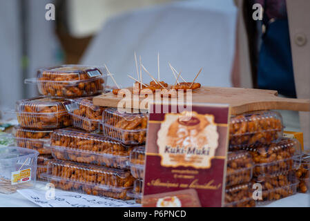 RIGA, Lettonia - 22 giugno 2018: solstizio d'estate mercato. Campioni di mais caramellato sul mercato. Gli acquirenti possono gustare loro. Foto Stock