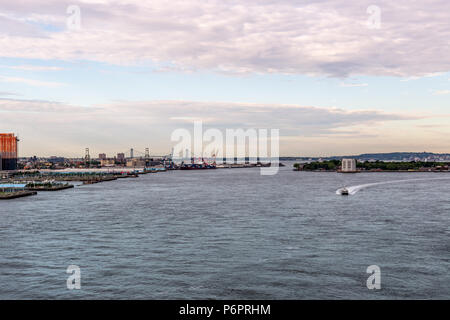 La città di New York / STATI UNITI D'America - 20 GIU 2018: East River con piloni di Brooklyn e Governors Island al mattino presto nella città di New York Foto Stock