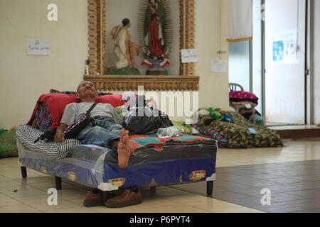 Escuintla, Guatemala. Il 29 giugno, 2018. Un uomo anziano è dotato di tutto ciò che egli ha ancora ed è giacente su un letto nel riparo di emergenza presso la chiesa "Nuestra Senora de Guadalupe'. Il rifugio è stato istituito per le persone che sono state effettuate dall'eruzione vulcanica del 3 giugno. L'uomo è ora in attesa di essere portati a nuovo alloggio di emergenza. L'eruzione ha ucciso almeno 110 persone. I dati del governo suggerisce che 186 case sono state completamente distrutte e un ulteriore 750 sono stati gravemente danneggiati. Credito: Morena Perez Joachin/dpa/Alamy Live News Foto Stock