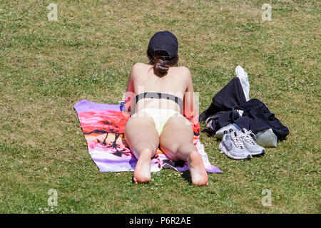 Bath, Regno Unito, 2 luglio, 2018. Come bagno gode di un altro molto calda e soleggiata giornata di una donna nella vasca da bagno's Parade Gardens è raffigurato godendo il sole, forecasters prevedono che il clima caldo proseguirà anche nella prossima settimana. Credito: lynchpics/Alamy Live News Foto Stock