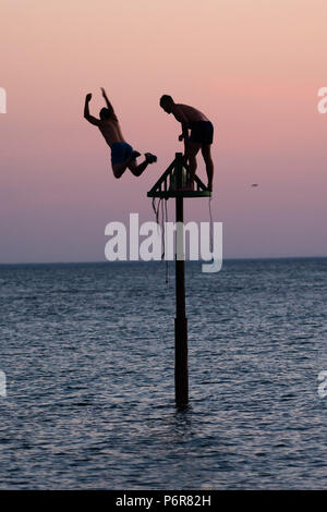 Aberystwyth, UK. 02Luglio, 2018. Regno Unito Regno Unito Meteo:giovani uomini salto in mare fresco in Aberystwyth alla fine di ancora un altro faceva un caldo tremendo e il giorno senza nuvole, come la prolungata ondata di caldo continua a dominare il tempo al di sopra del Regno Unito. Photo credit: keith morris/Alamy Live News Foto Stock