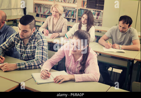 Adulto felice professionisti tenendo note alla sessione di formazione per i dipendenti Foto Stock