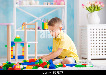 Ragazzo gioca a cubetti e il progettista della casa Foto Stock