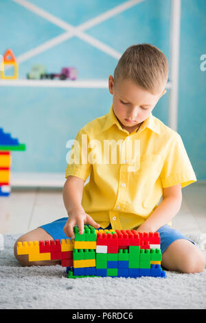 Ragazzo gioca a cubetti e il progettista della casa Foto Stock