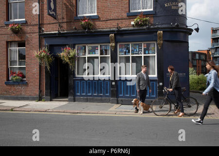 Donna che cammina e giovane con un cane in chat al di fuori il grasso gatto Real Ale Pub in Sheffield Foto Stock