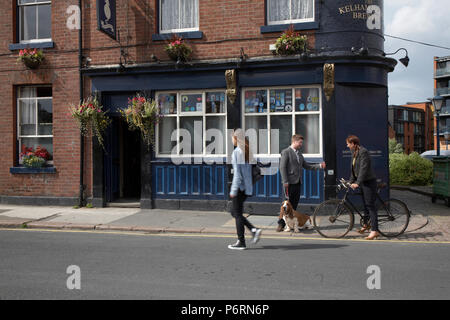 Donna che cammina e giovane con un cane in chat al di fuori il grasso gatto Real Ale Pub in Sheffield Foto Stock