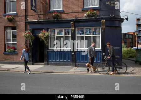 Donna che cammina e giovane con un cane in chat al di fuori il grasso gatto Real Ale Pub in Sheffield Foto Stock