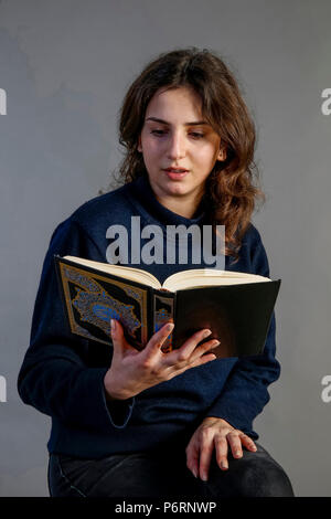 Giovane donna lettura kuran. Parigi, Francia. Foto Stock