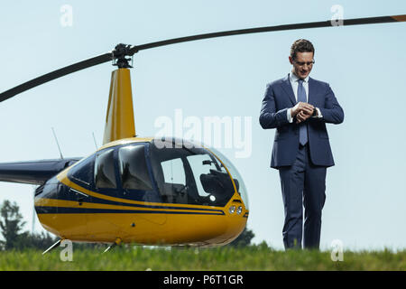 Bel giovane controllo esecutivo tempo a sinistra prima del volo Foto Stock