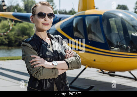 Bellissima femmina ponendo pilota presso l'Eliporto Foto Stock
