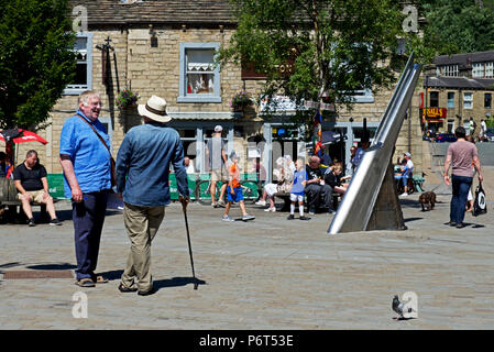Conversazione in St George Square, Hebden Bridge, Calderdale, West Yorkshire, Inghilterra, Regno Unito Foto Stock