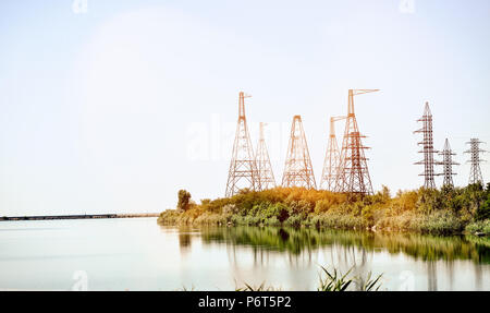 Alta tensione poli al di fuori del lago. Blue River. Foto Stock