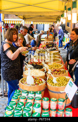 Olive, in piccole botti di rovere, essendo venduto sul mercato in stallo durante il sandwich della città di Le Weekend festival francese. Donna, 40s, indicando alcuni prima di acquistare. Foto Stock