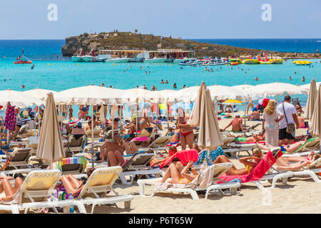 I turisti a prendere il sole sulla spiaggia di Nissi Bay nei pressi di Ayia Napa, Cipro Foto Stock