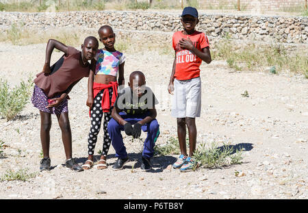 KHOHAXIS, NAMIBIA - 21 maggio 2018; quattro giovani africani due ragazze e due ragazzi di godere in posa per una foto Foto Stock