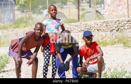 KHOHAXIS, NAMIBIA - 21 maggio 2018; quattro giovani africani due ragazze e due ragazzi di godere in posa per una foto Foto Stock