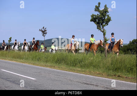 Oberoderwitz, donne e giovani ragazze a cavallo accanto a una strada di campagna Foto Stock